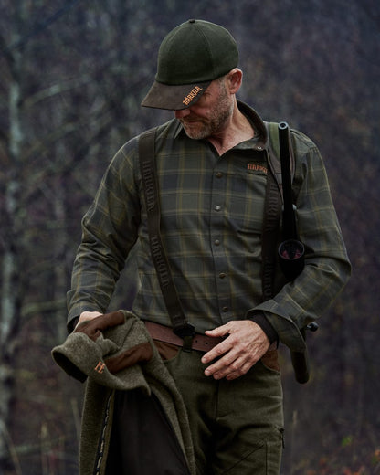 Willow Green Check colour Harkila Metso Active Shirt on blurry background #colour_willow-green-check