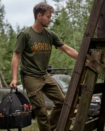 Rosin Coloured Harkila Modi Short Sleeve T-Shirt on forest background #colour_rosin