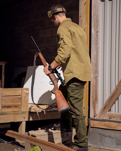 Hunting Green Shadow Brown Coloured Harkila Mountain Hunter Trousers on outdoor background #colour_hunting-green-shadow-brown