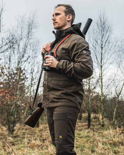 Willow Green Coloured Harkila Nordic Hunter HWS Jacket on outdoor background #colour_willow-green