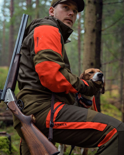 Willow Green Orange Coloured Harkila Pro Hunter Dog Keeper GTX Trousers on forest background #colour_willow-green-orange