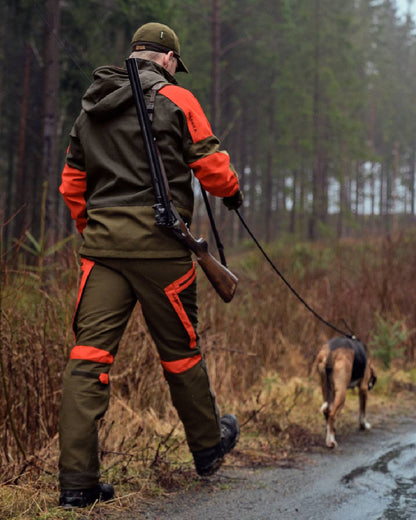 Willow Green Orange Coloured Harkila Pro Hunter Dog Keeper GTX Trousers on forest background #colour_willow-green-orange