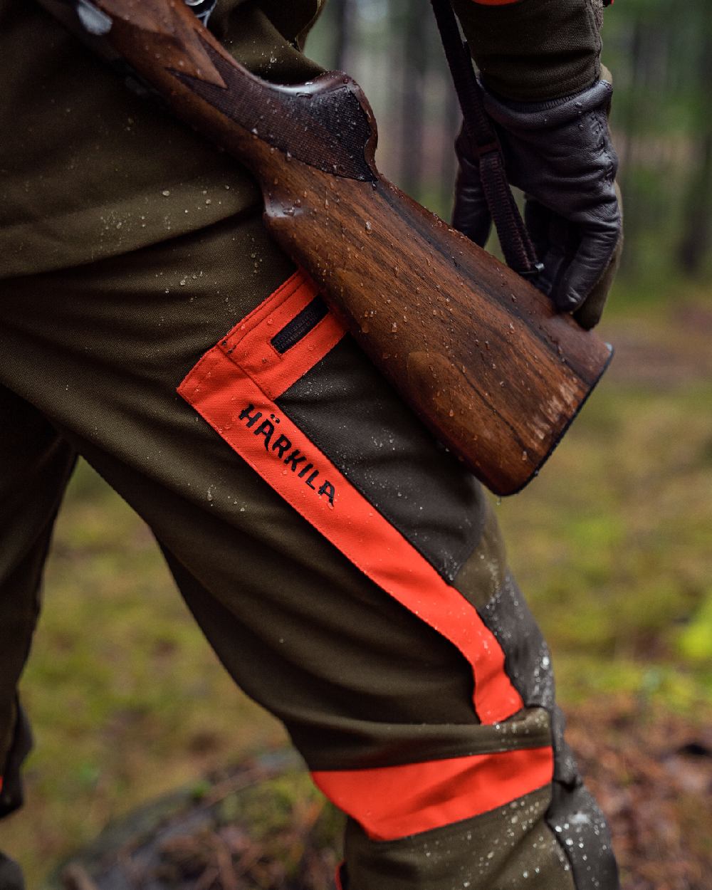 Willow Green Orange Coloured Harkila Pro Hunter Dog Keeper GTX Trousers on forest background #colour_willow-green-orange