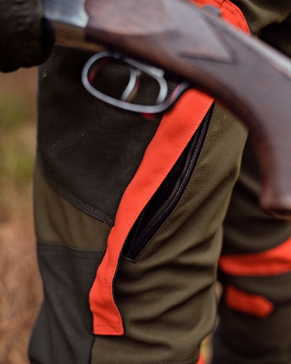 Willow Green Orange Coloured Harkila Pro Hunter Dog Keeper GTX Trousers on forest background #colour_willow-green-orange