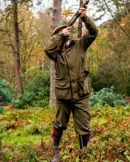 Willow Green Coloured Harkila Pro Hunter Endure Jacket on forest background #colour_willow-green