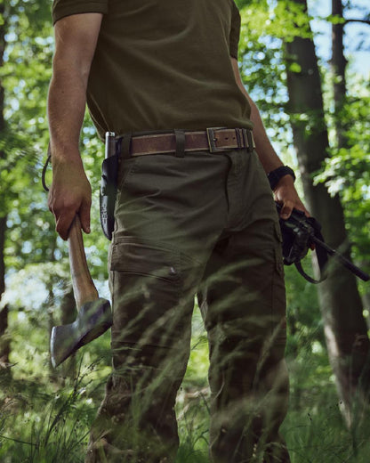 Light Willow Green Coloured Harkila Pro Hunter Light Trousers on forest background #colour_light-willow-green