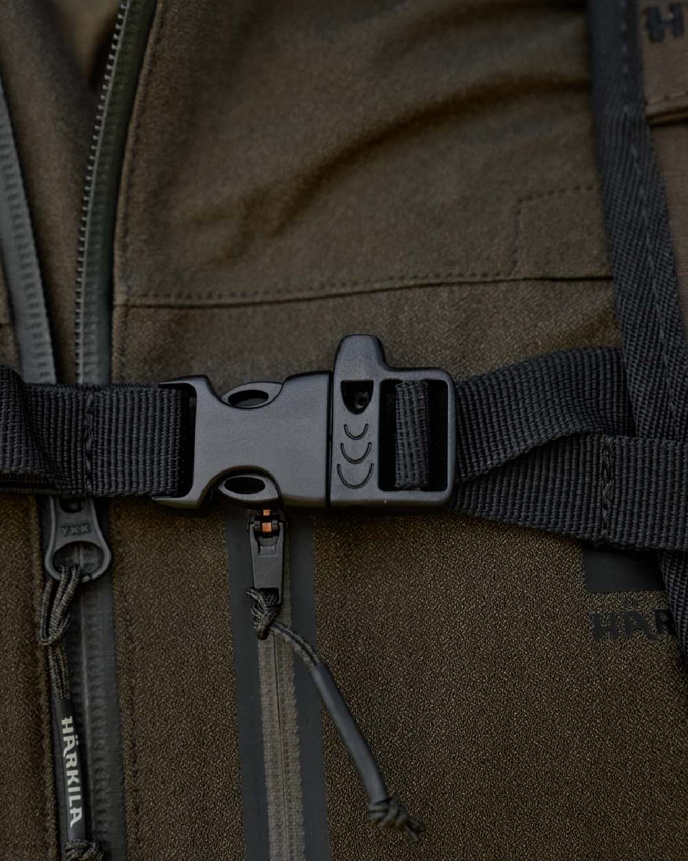 Willow Green Coloured Harkila Ragnar First Aid Backpack on blurry background #colour_willow-green