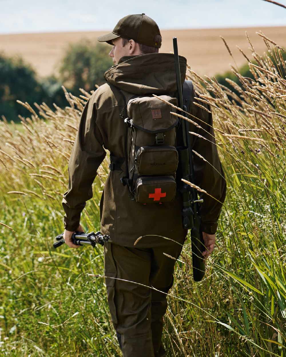 Willow Green Coloured Harkila Ragnar First Aid Backpack on forest background #colour_willow-green