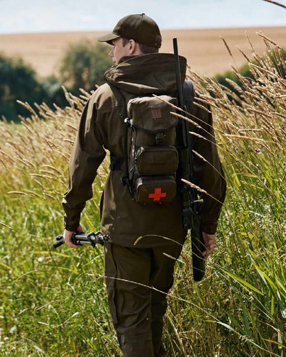 Willow Green Coloured Harkila Ragnar First Aid Backpack on forest background #colour_willow-green