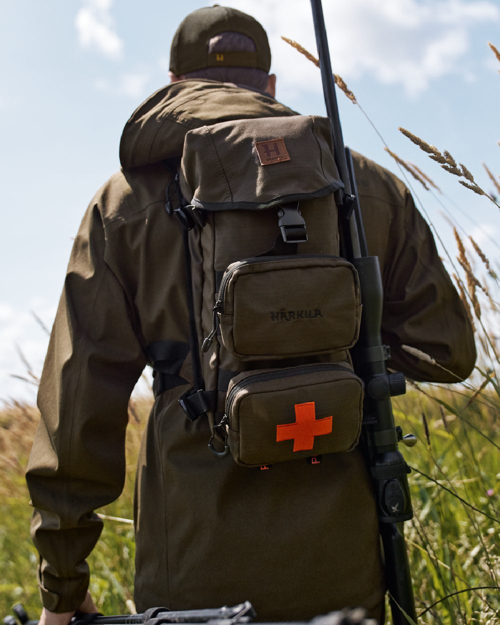Willow Green Coloured Harkila Ragnar First Aid Backpack on forest background #colour_willow-green