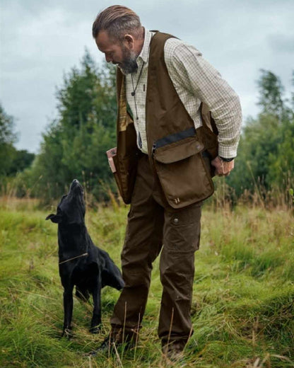 Warm Olive Coloured Harkila Retrieve Dummy Waistcoat on outdoor background #colour_warm-olive
