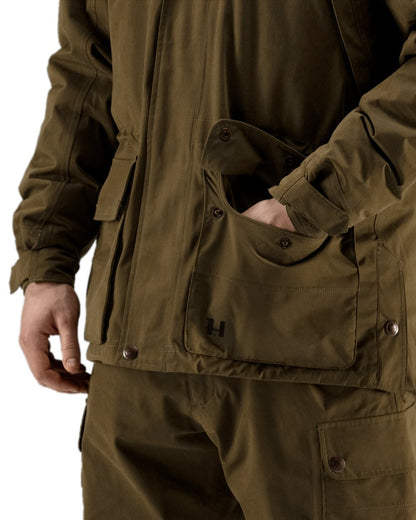 Warm Olive Coloured Harkila Retrieve Jacket on white background #colour_warm-olive