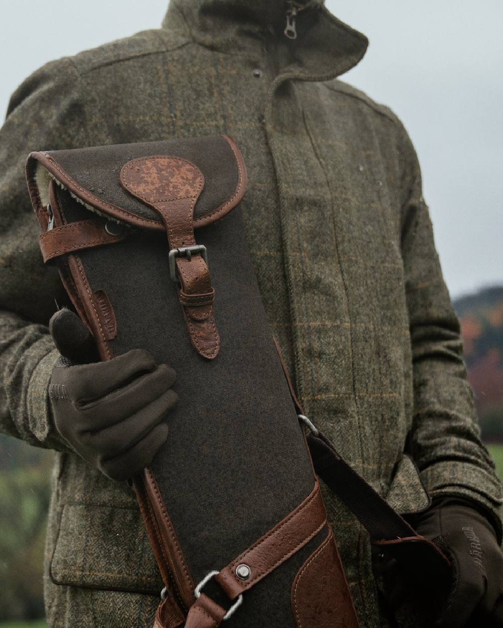 Warm Olive Coloured Harkila Retrieve Shotgun Slip on blurry background #colour_warm-olive