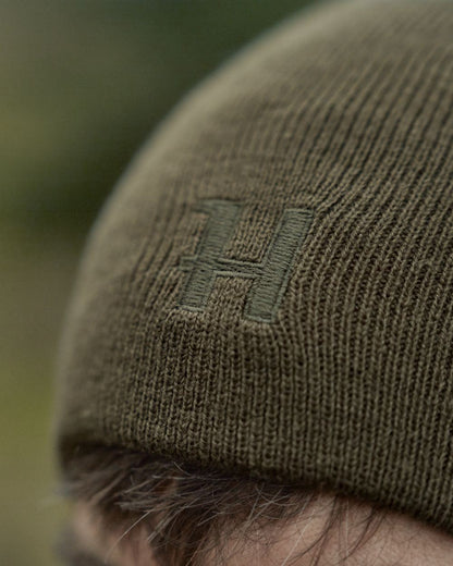 Willow Green Orange Coloured Harkila Reversible Beanie on outdoor background #colour_willow-green-orange
