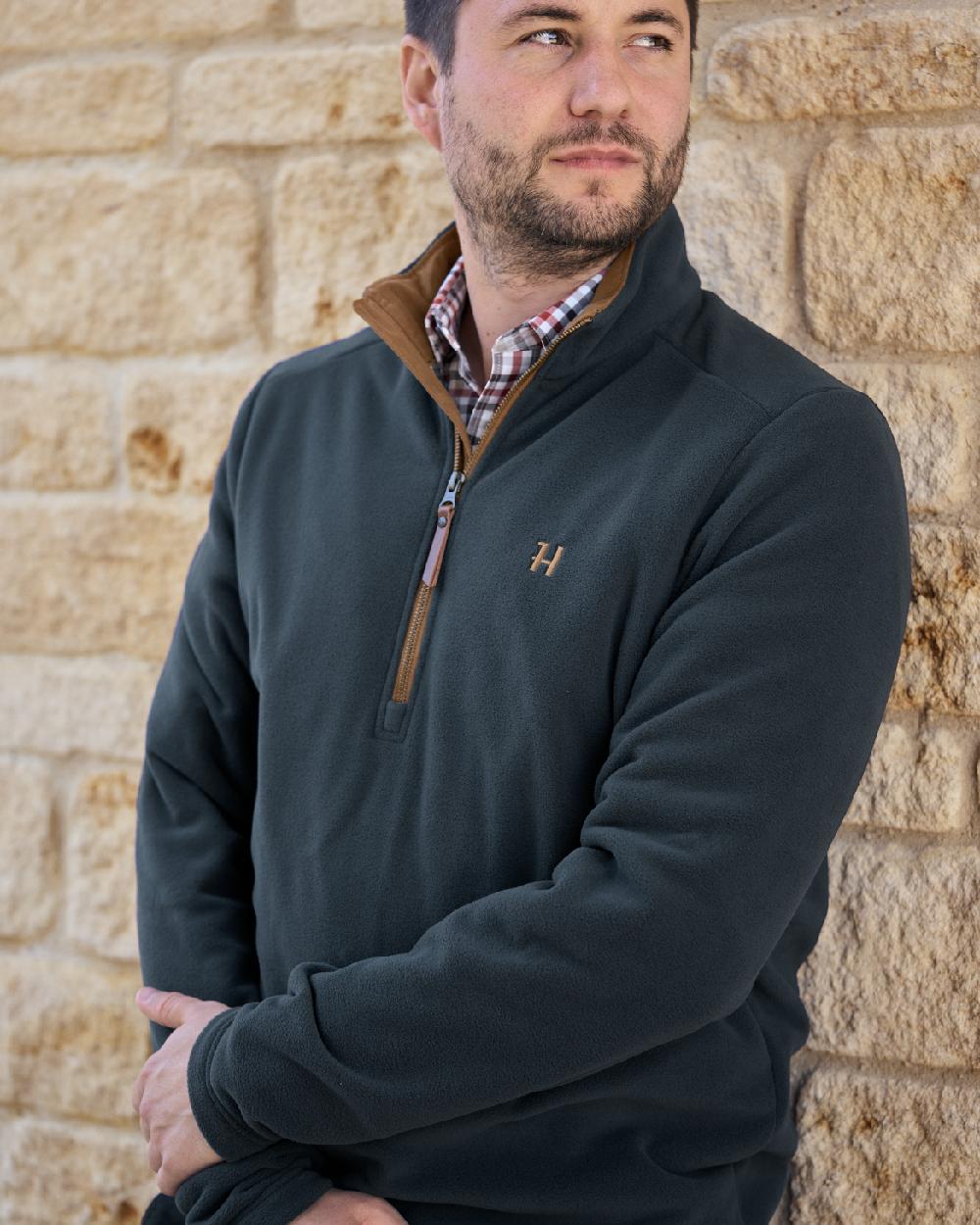 Dark Navy Coloured Harkila Sandhem 200 Fleece Pullover on wall background #colour_dark-navy