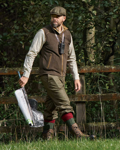 Demitasse Brown Coloured Harkila Sandhem 200 Fleece Waistcoat on forest background #colour_demitasse-brown