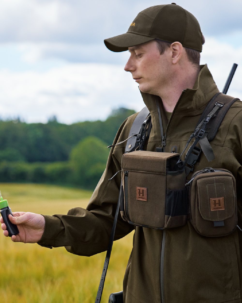 Dark Willow Green Coloured Harkila Utility Pouch on blurry background #colour_dark-willow-green