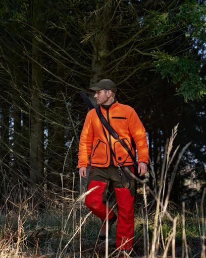 Orange Blaze Coloured Harkila Wildboar Pro Blaze Fleece Jacket on forest background #colour_orange-blaze