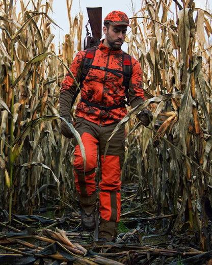 Wildboar Orange Coloured Harkila Wildboar Pro Camo Fleece Jacket on farm background #colour_wildboar-orange