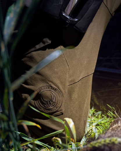 Willow Green Coloured Harkila Wildboar Pro Move Trousers on outdoor background #colour_willow-green