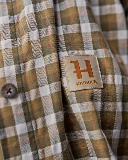 Dark Olive Check Coloured Harkila Womens Fjell Long Sleeve Shirt on blurry background #colour_dark-olive-check