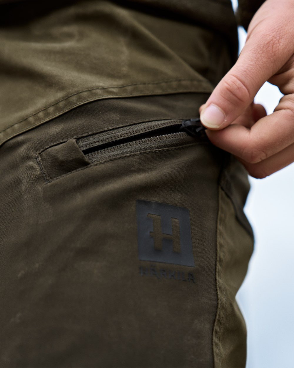 Dark Olive Willow Green Coloured Harkila Womens Fjell Trousers on blurry background #colour_dark-olive-willow-green