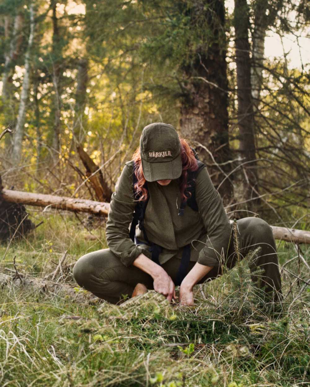 Willow Green Coloured Harkila Womens Herlet Tech Shirt on forest background #colour_willow-green