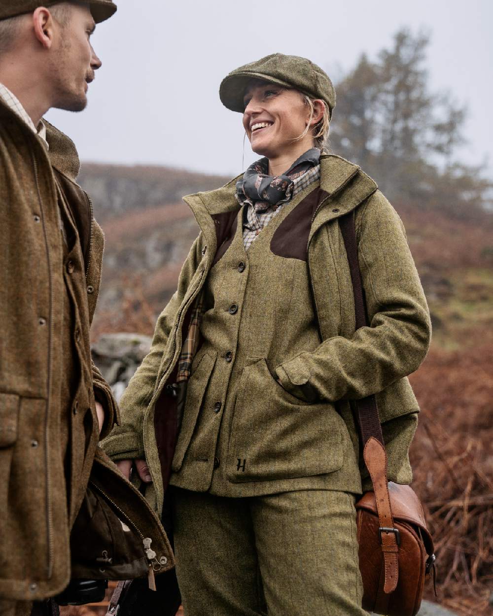 Olive Coloured Harkila Womens Jura Shooting Waistcoat on forest background #colour_olive