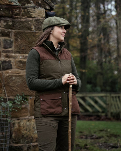 Dark Warm Olive Burgundy Coloured Harkila Womens Retrieve Waistcoat on outdoor background #colour_dark-warm-olive-burgundy