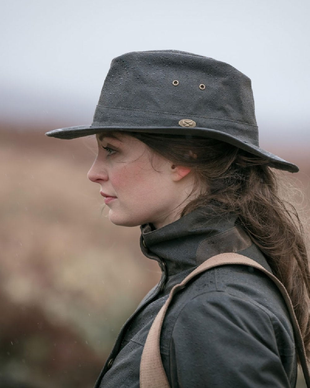 Antique Olive Coloured Hoggs of Fife Caledonia Waxed Hat on blurry background #colour_antique-olive
