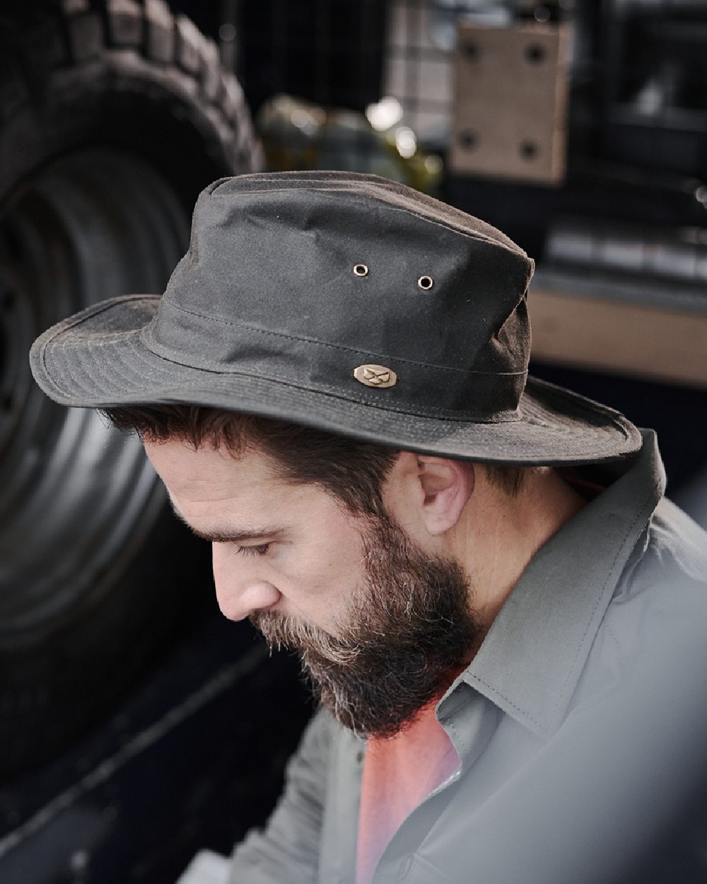 Antique Olive Coloured Hoggs of Fife Caledonia Waxed Hat on blurry background #colour_antique-olive