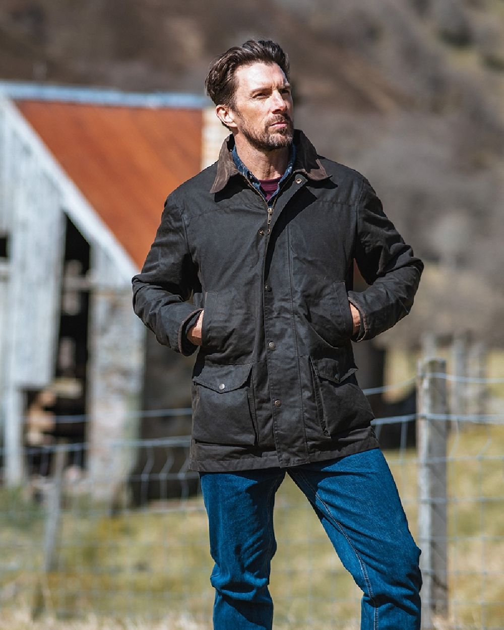 Olive Coloured Hoggs of Fife Caledonia Waxed Jacket on blurry background #colour_olive