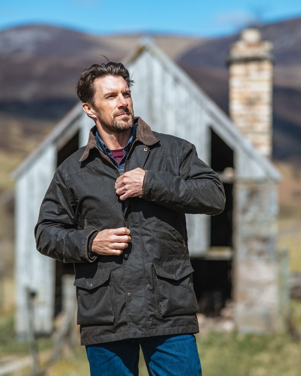 Olive Coloured Hoggs of Fife Caledonia Waxed Jacket on house background #colour_olive