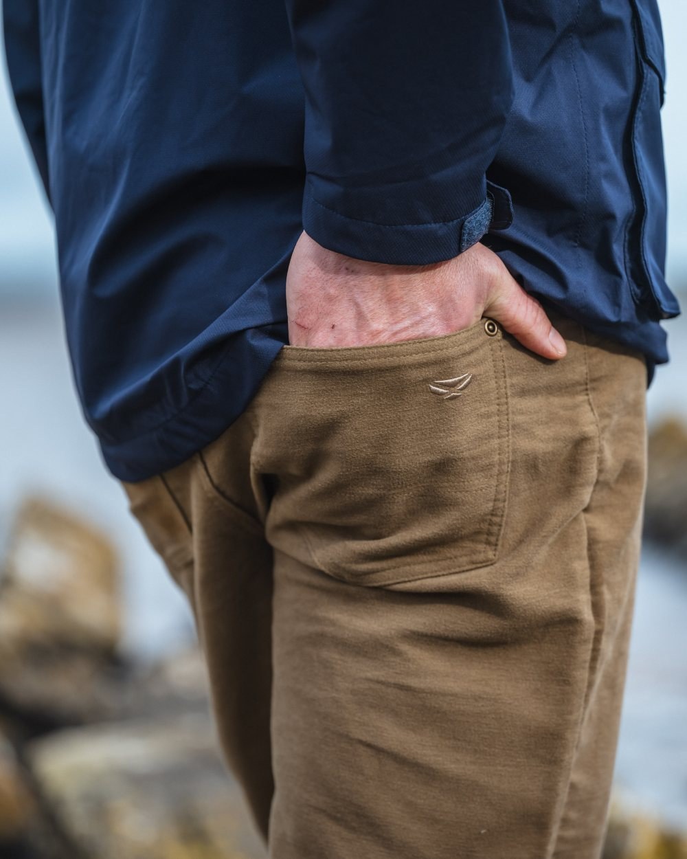 Dried Moss Coloured Hoggs of Fife Carrick Technical Stretch Moleskin Jeans on blurry background #colour_dried-moss