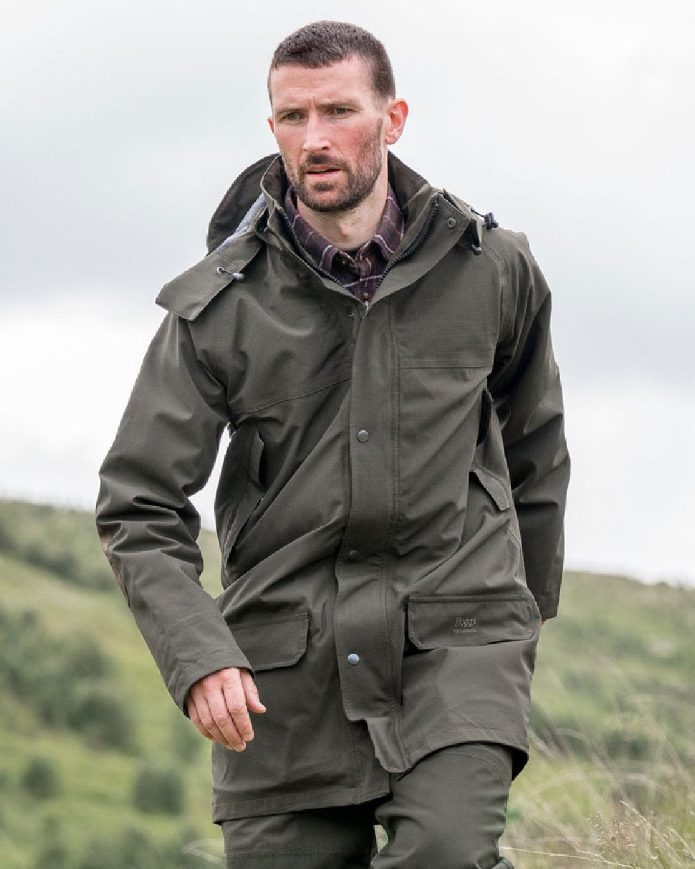 Green Coloured Hoggs of Fife Green King II Waterproof Jacket on blurry background #colour_green