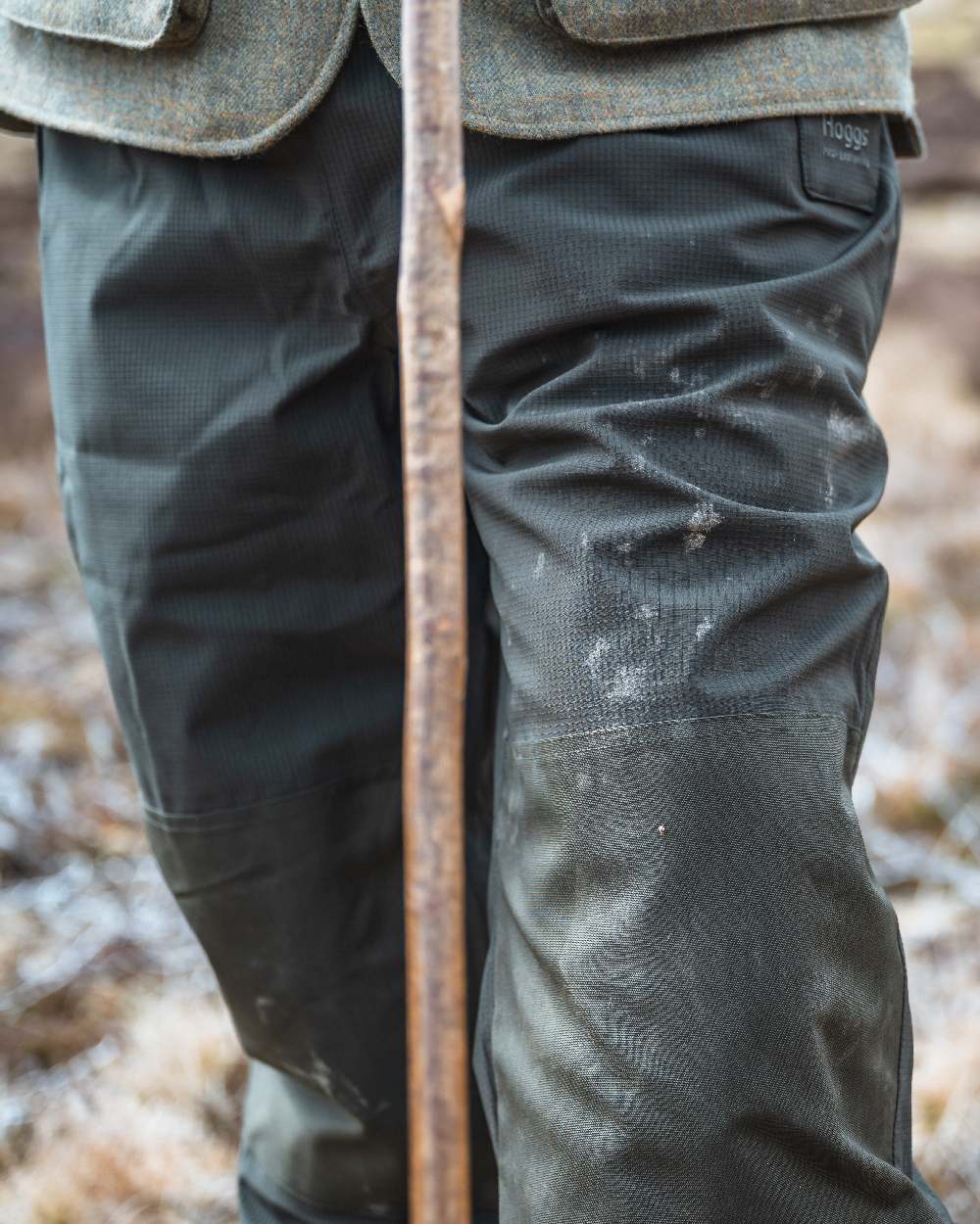 Green Coloured Hoggs of Fife Green King II Waterproof Trousers on blurry background #colour_green