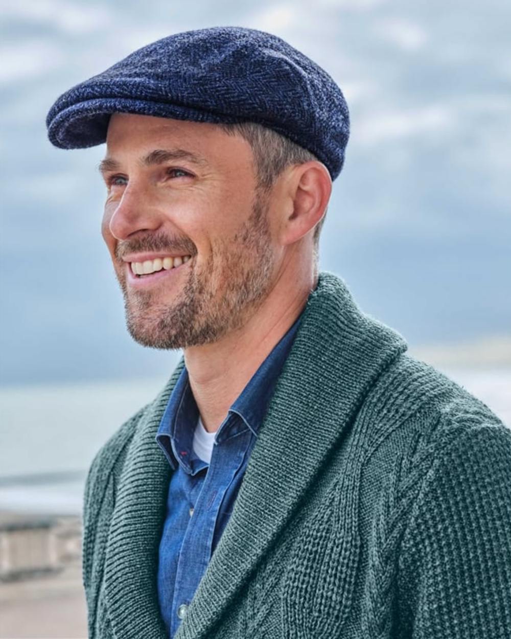 Navy Coloured Hoggs of Fife Herringbone Waterproof Tweed Flat Cap on sky background #colour_navy