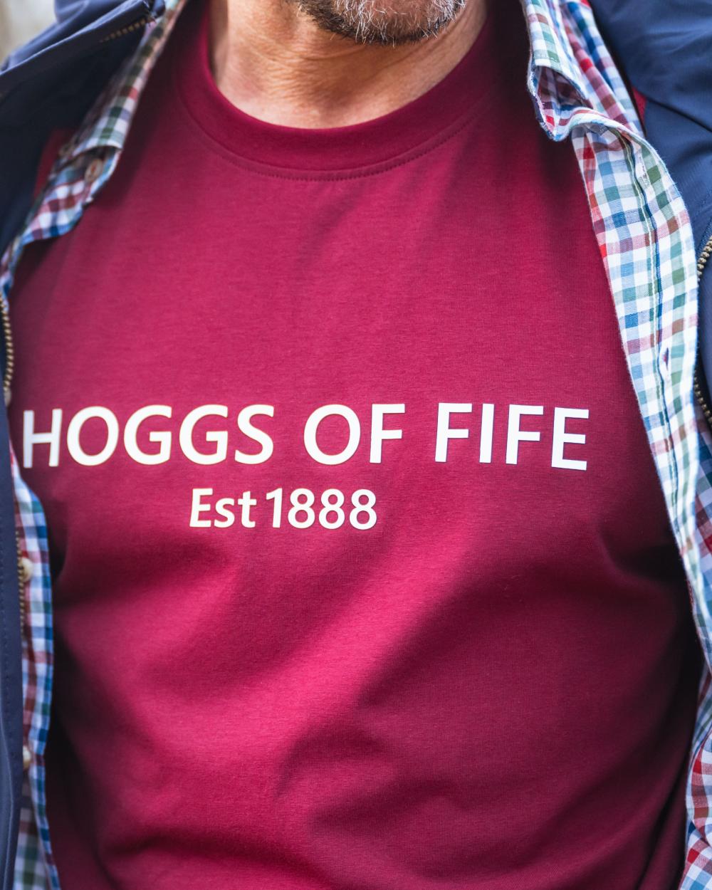 Burgundy Coloured Hoggs of Fife Mens Canonbie Printed T-Shirt on blurry background #colour_burgundy