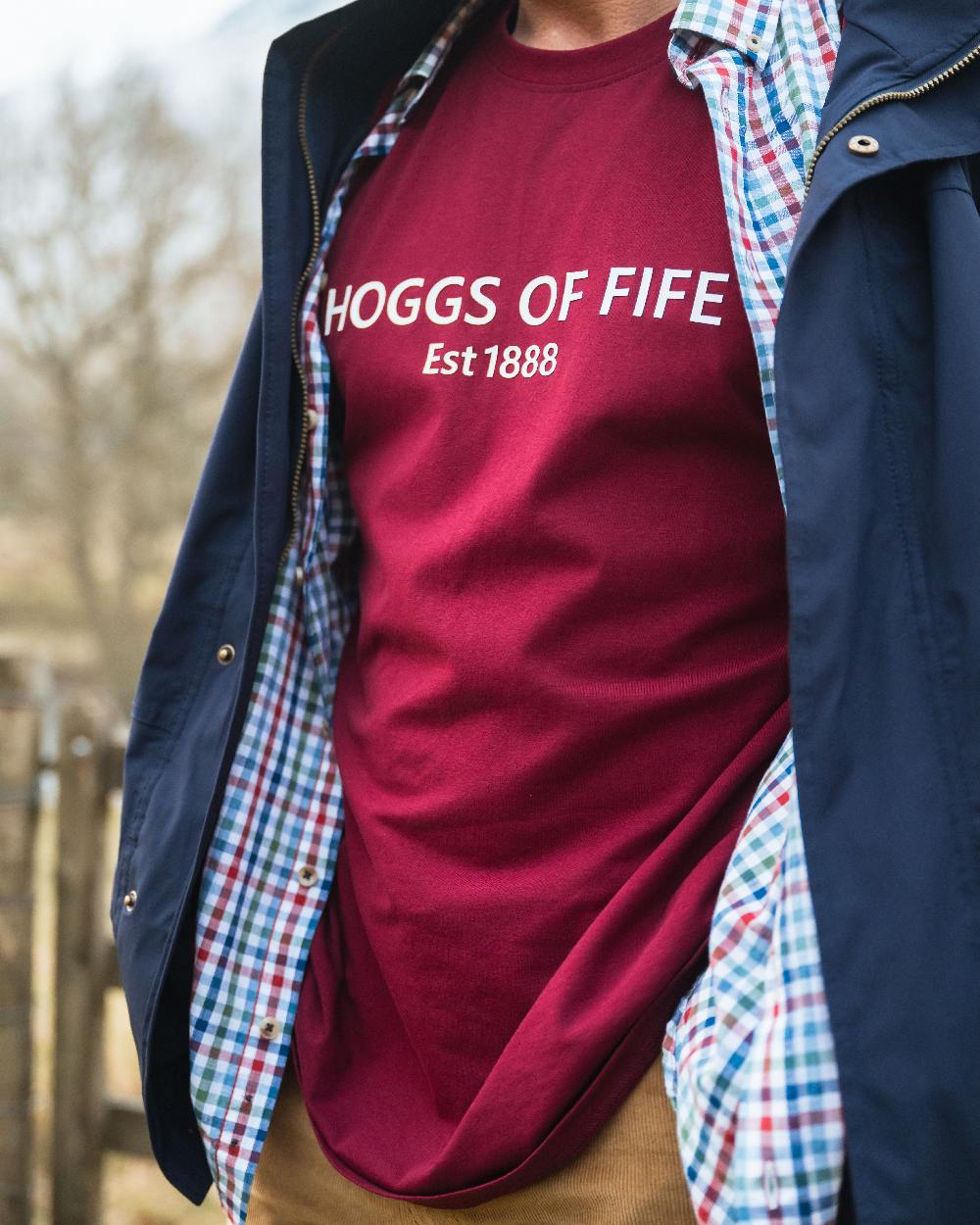 Burgundy Coloured Hoggs of Fife Mens Canonbie Printed T-Shirt on blurry background #colour_burgundy