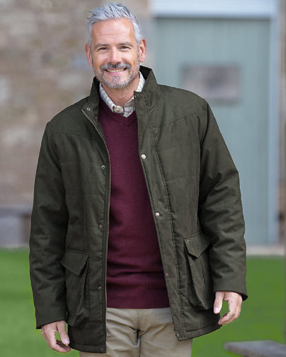Loden coloured Hoggs of Fife Mens Glenesk Quilted Jacket on blurry background #colour_loden