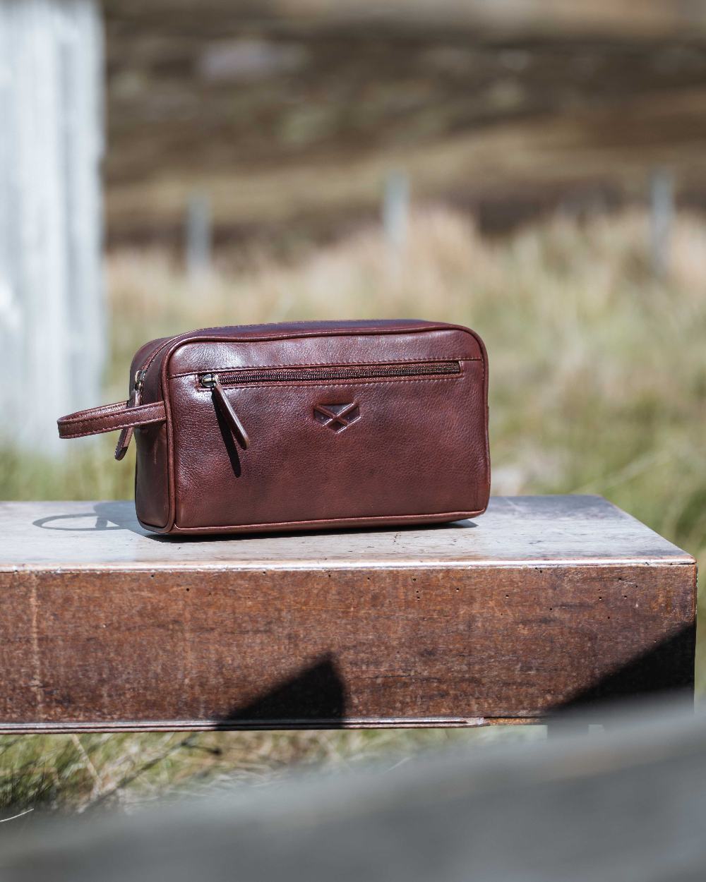 Conker Coloured Hoggs of Fife Monarch Leather Wash Bag on outdoor background #colour_conker