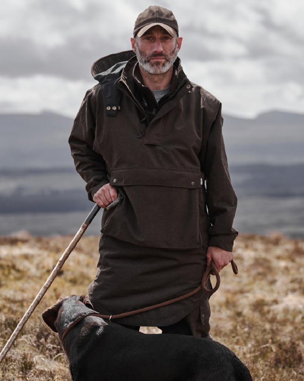 Dark Green coloured Hoggs of Fife Struther Trilaminate Long Waterproof Smock on forest background #colour_dark-green