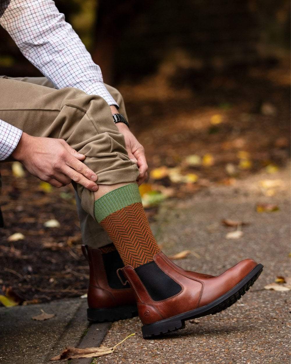 Ivy Green coloured House of Cheviot Herringbone Short Socks on blurry background #colour_ivy-green