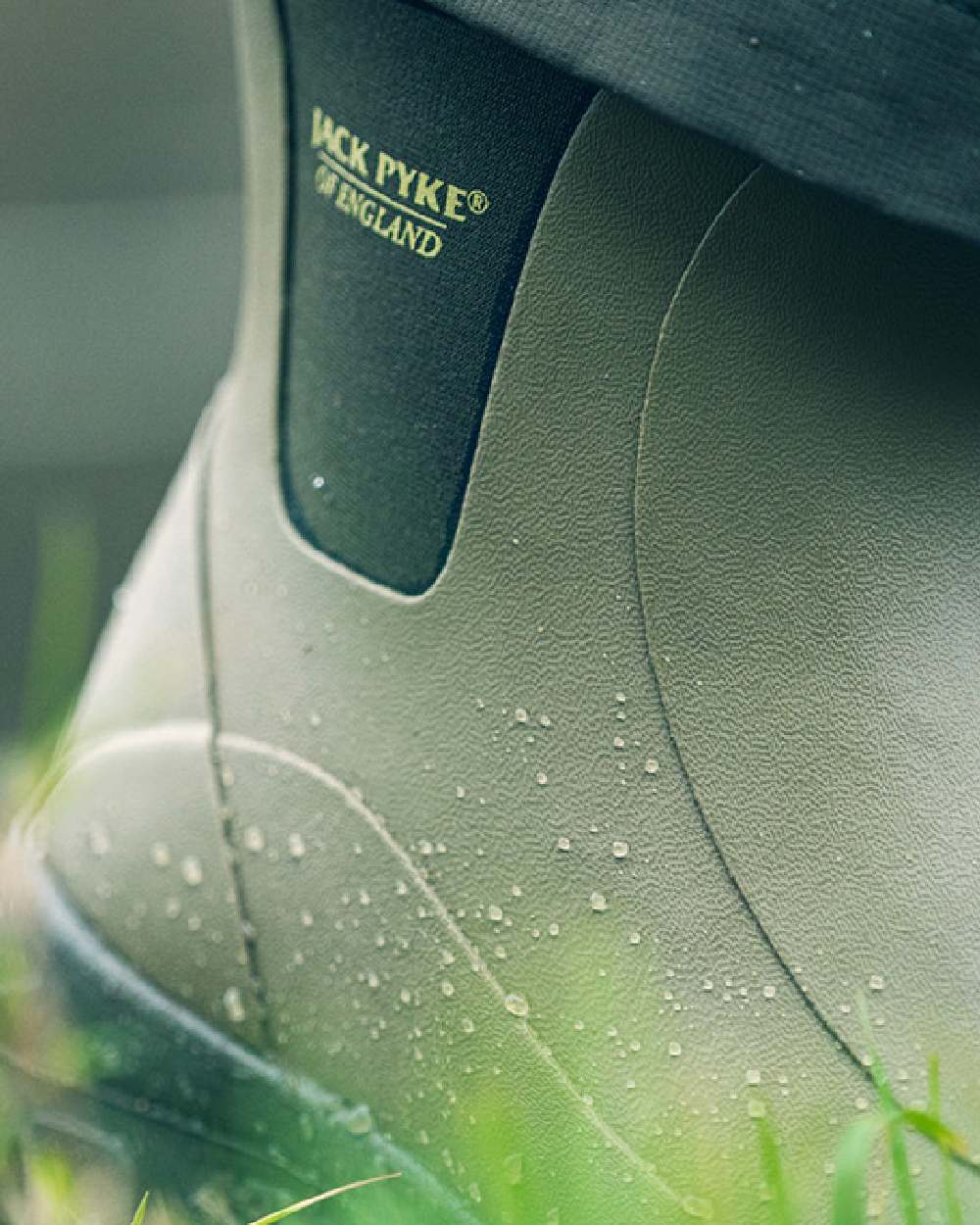 Green coloured Jack Pyke Ankle Wellington Boots on grass background #colour_green