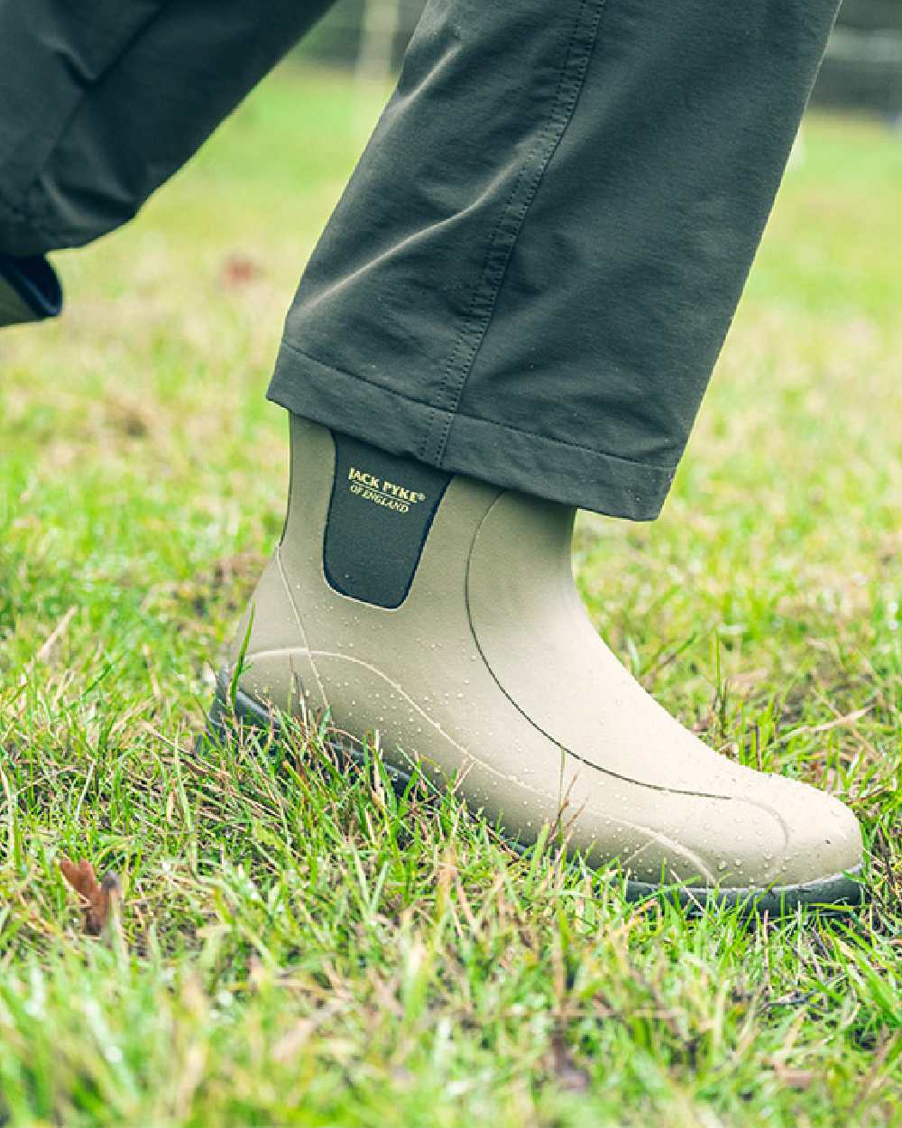 Green coloured Jack Pyke Ankle Wellington Boots on grass background #colour_green