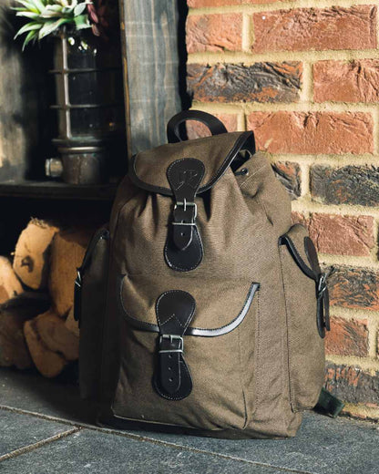 Green coloured Jack Pyke Canvas Day Pack on wall background #colour_green