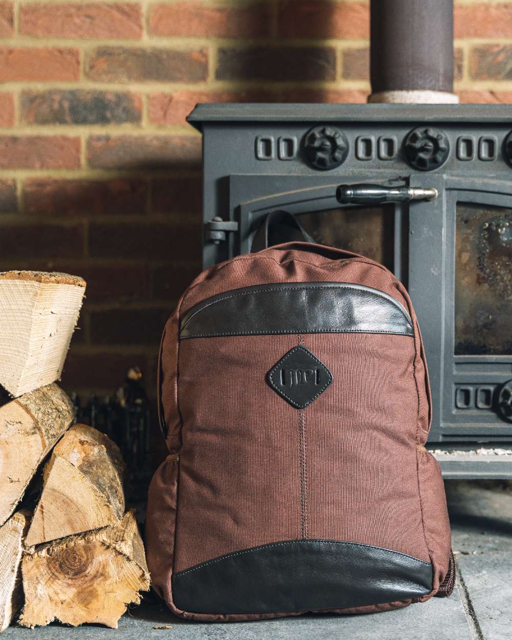 Brown coloured Jack Pyke Canvas Field Pack on brick wall background #colour_brown