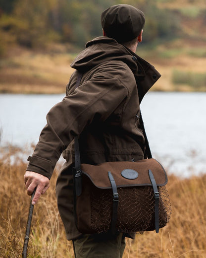 Brown coloured Jack Pyke Canvas Game Bag on grassy background #colour_brown