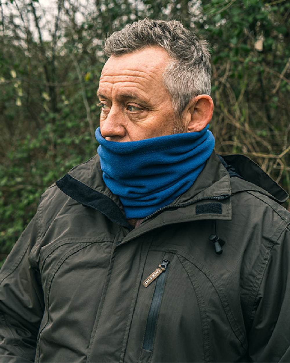 Denim coloured Jack Pyke Country Fleece Neck Gaiter on forest background #colour_denim