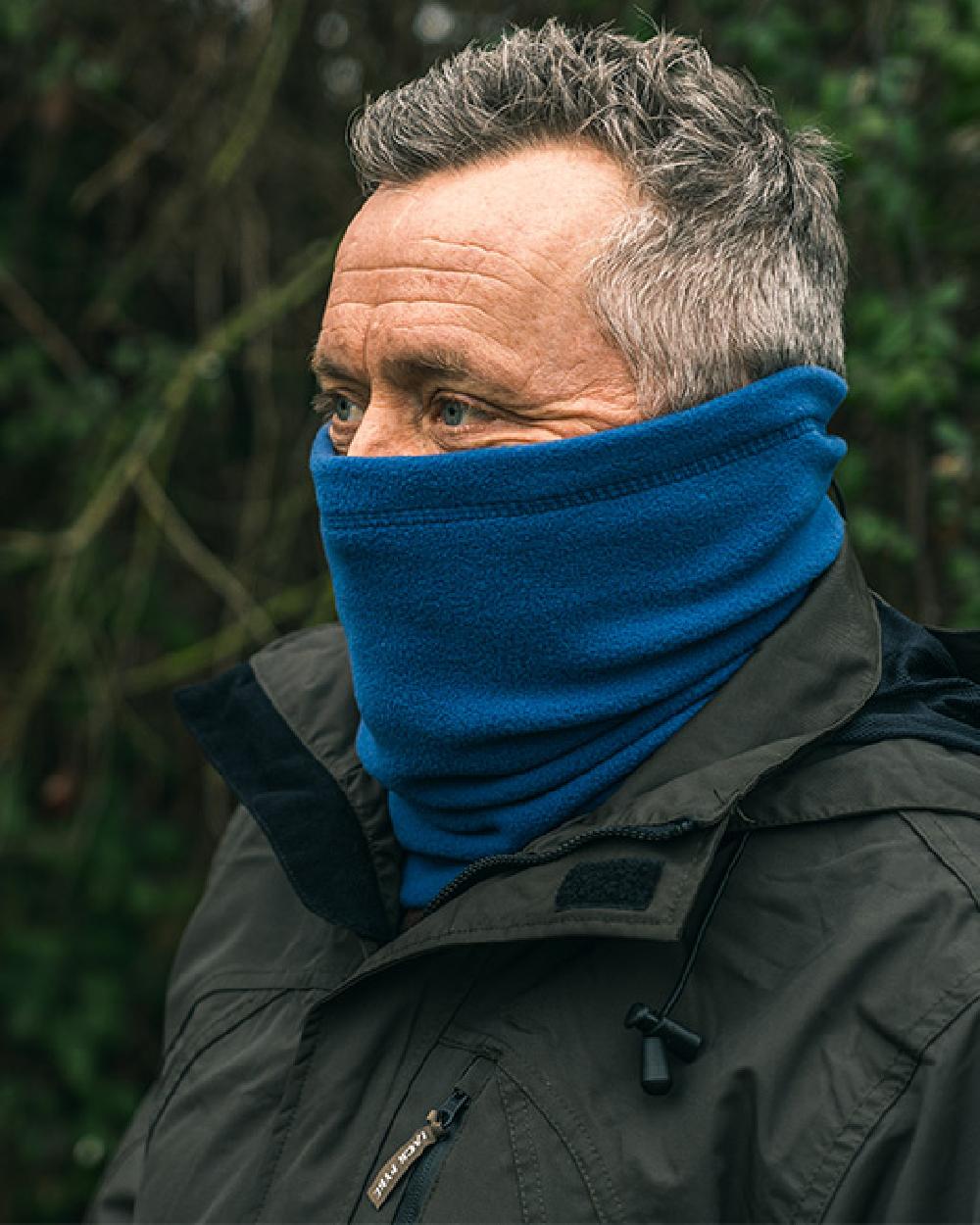 Denim coloured Jack Pyke Country Fleece Neck Gaiter on forest background #colour_denim